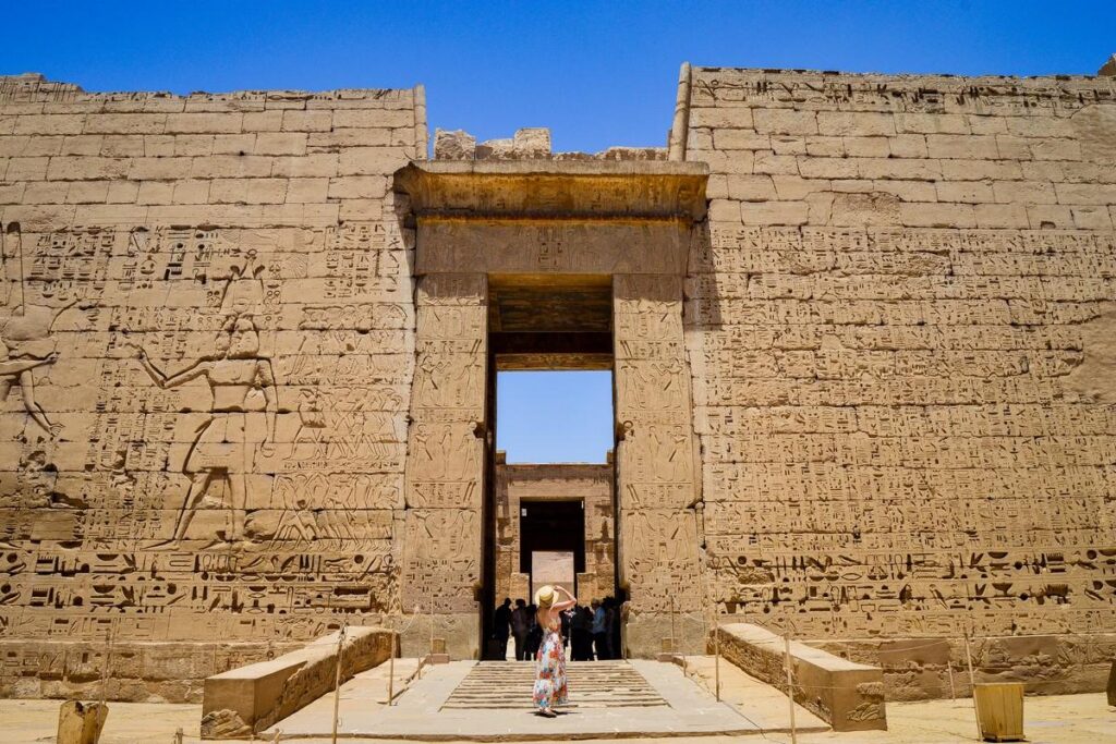 Visitor at the grand entrance with hieroglyphics