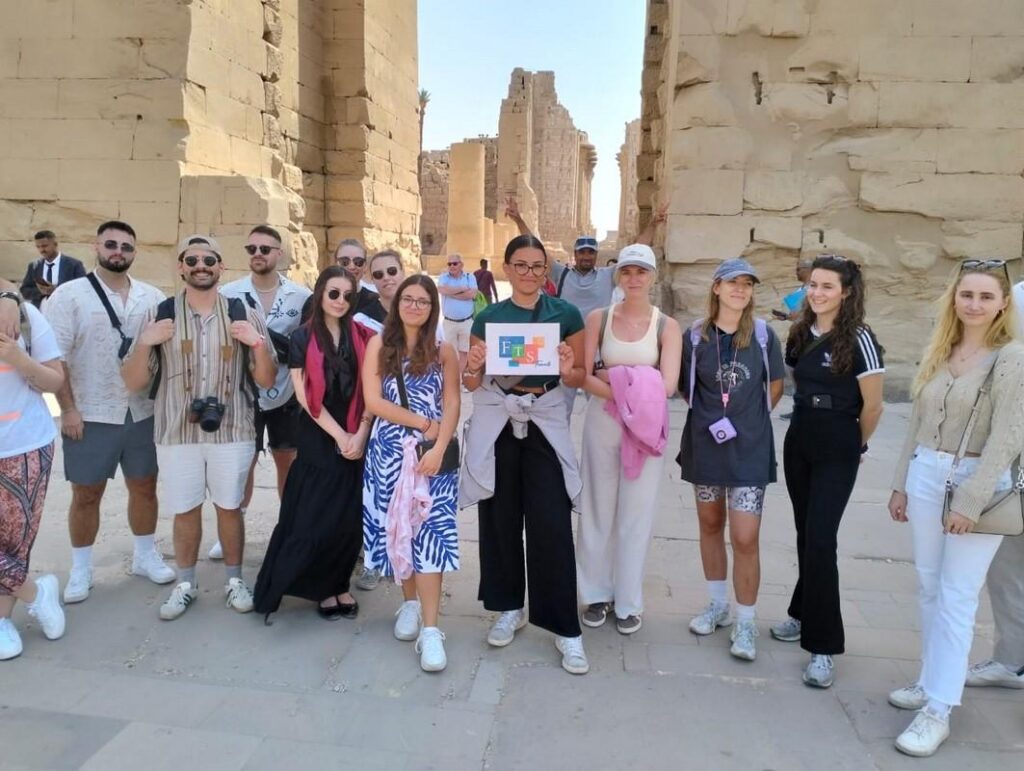 Tourists posing in front of ancient stone structures