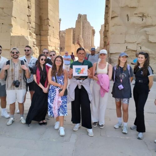Tourists posing in front of ancient stone structures