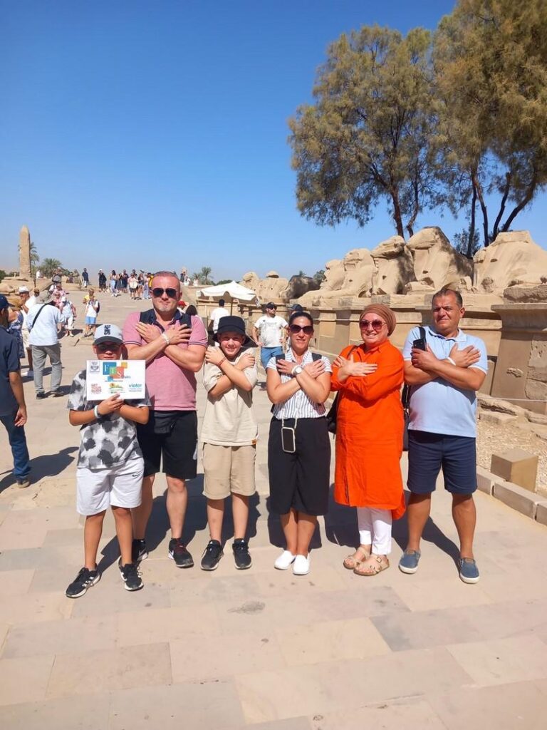 Tourists posing with arms crossed at an ancient site.